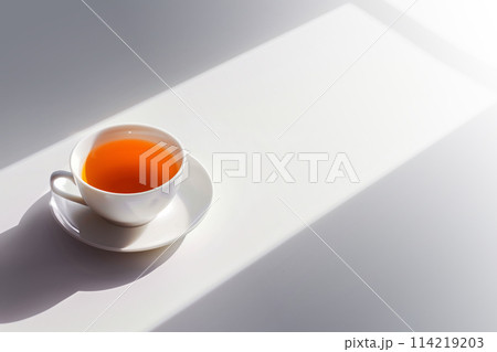 White cup of tea with a sharp shadow on a bright white surface with copy space White cup of tea with a sharp shadow on a bright white surface with copy space 114219203