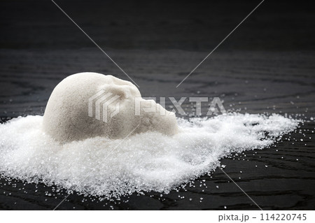 A skull-shaped sugar mound on a wooden surface symbolizing the concept of unhealthy diet A skull-shaped sugar mound on a wooden surface symbolizing the concept of unhealthy diet 114220745