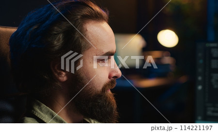 Man getting scared while programming after AI becomes sentient, afraid of it spiraling out of control and dooming humanity. Developer worried by conscious artificial intelligence, camera A close up 114221197