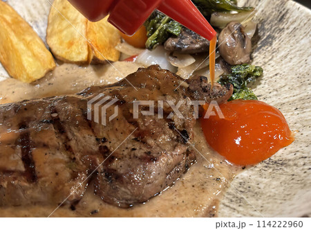 Sirloin steak grilled medium rare served with potatoes and salad with mushroom black pepper sauce 114222960