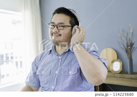 自宅で音楽を聴く大柄な日本人男性 114225680