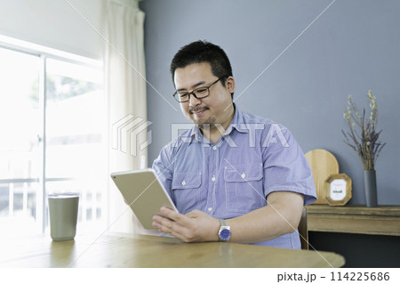 タブレット端末でイラストを描く大柄な日本人男性 114225686