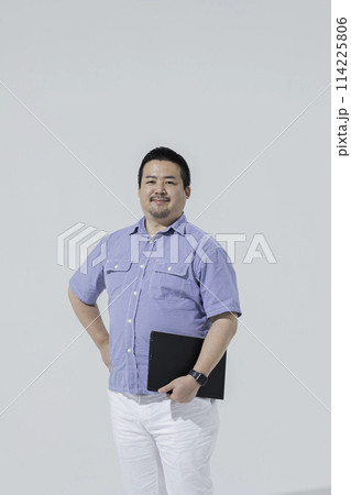 ノートパソコンを持った大柄な日本人男性 114225806