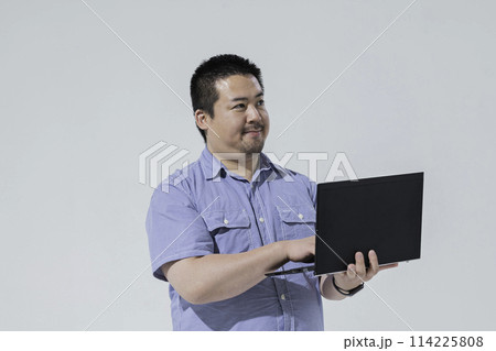 ノートパソコンを持った大柄な日本人男性 114225808