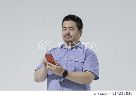 スマートフォンを見る大柄な日本人男性 114225830