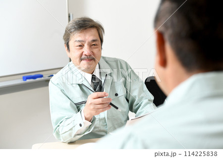 会話をする笑顔の中高年の男性作業員達 会話をする笑顔の中高年の男性作業員達 114225838