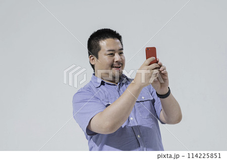 スマートフォンで写真を撮る大柄な日本人男性 スマートフォンで写真を撮る大柄な日本人男性 114225851