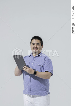 タブレット端末を使う大柄な日本人男性 114225878