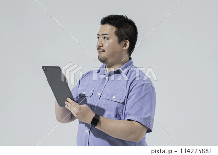 タブレット端末を使う大柄な日本人男性 114225881