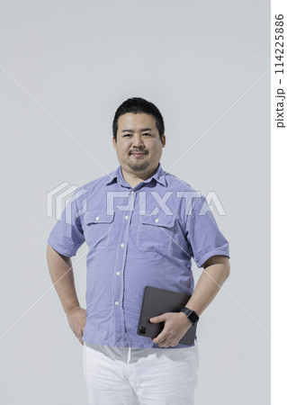 タブレット端末を持った大柄な日本人男性 114225886