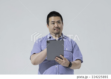 タブレット端末を使う大柄な日本人男性 114225891