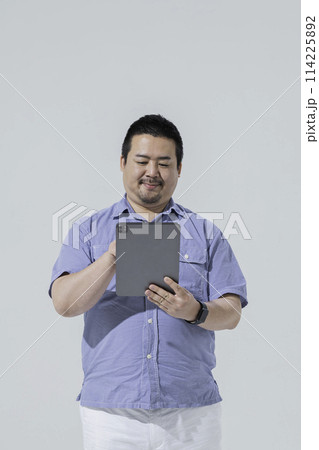 タブレット端末を使う大柄な日本人男性 タブレット端末を使う大柄な日本人男性 114225892