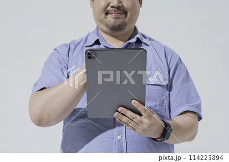 タブレット端末を使う大柄な日本人男性 タブレット端末を使う大柄な日本人男性 114225894