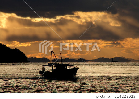 大角鼻の夕焼けの中を港に帰る漁船 114228925