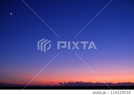 夕暮れの空に浮かぶ三日月 114229558