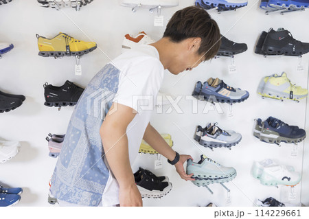 スポーツアパレルショップで買い物をする若い男性 114229661