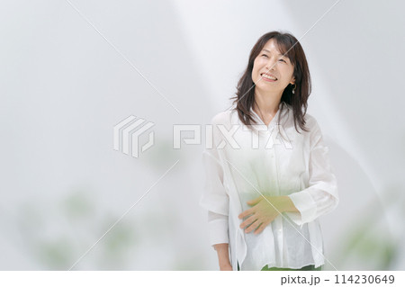 白いシャツのミドル女性 114230649