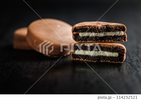 Close-Up View of Chocolate-Coated Sandwich Cookies on Dark Background Close-Up View of Chocolate-Coated Sandwich Cookies on Dark Background 114232521
