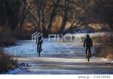 Winter cycling on icy trail Winter cycling on icy trail 114234088
