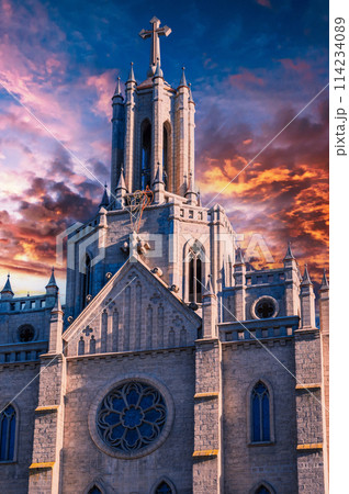 tower and spire of the gothic old ancient Catholic Cathedral on background of dramatic cloudy sky at sunset. Church of Sacred Heart of Jesus in Tashkent in Uzbekistan, Asia tower and spire of the gothic old ancient Catholic Cathedral on background of dramatic cloudy sky at sunset. Church of Sacred Heart of Jesus in Tashkent in Uzbekistan, Asia 114234089