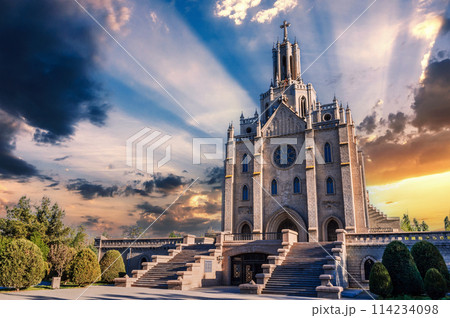 Ancient old stone Cathedral of Sacred Heart of Jesus in Tashkent in Uzbekistan. Facade of Catholic Church on background of cloudy beautiful sky at sunset in summer 114234098