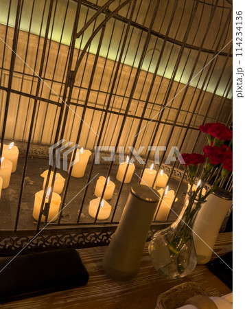 Carnation flowers in a vase and candles on a table in a restaurant 114234136