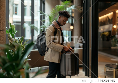 Man with luggage in hotel lobby Man with luggage in hotel lobby 114234143
