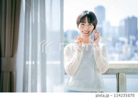 部屋でスマホを操作する女性 部屋でスマホを操作する女性 114235870