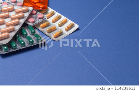 Different medicines: tablets, pills in blister pack, medications drugs on blue background. Close-up photo, copy space. Different medicines: tablets, pills in blister pack, medications drugs on blue background. Close-up photo, copy space. 114239613