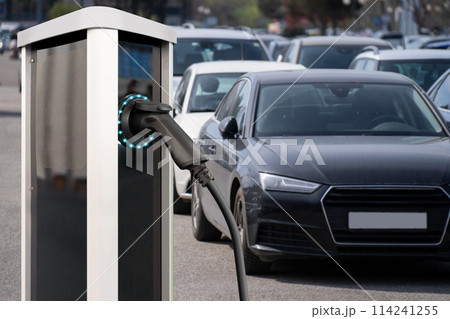 Electric vehicles charging station on a background of a row of cars. Concept 114241255