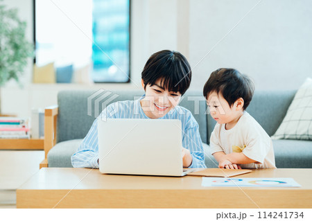 テレワーク中のママと仕事の邪魔をする男の子。 テレワーク中のママと仕事の邪魔をする男の子。 114241734
