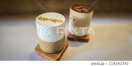 Fresh iced coffee in glass with frothy cream for your design, Food concept in style, copy space Fresh iced coffee in glass with frothy cream for your design, Food concept in style, copy space 114242342