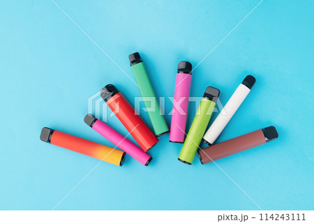 colorful disposable electronic cigarettes on a blue background. The concept of modern smoking colorful disposable electronic cigarettes on a blue background. The concept of modern smoking 114243111