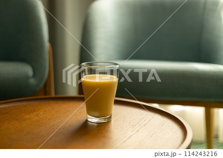 Interior of living room with coffee table with fresh juice. Fresh blended peach smoothie 114243216
