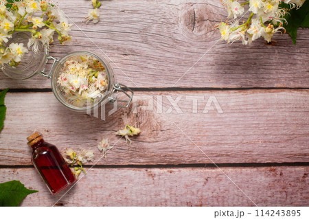 The extract of the flower of chestnut and chestnut flower isolated on a wooden background. Hairloss concept 114243895