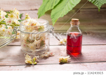 The extract of the flower of chestnut and chestnut flower isolated on a wooden background. Hairloss concept. Close up 114243915