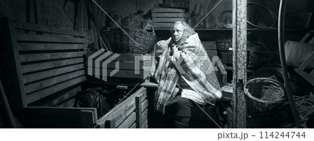 A woman hides in a cellar from shelling A woman hides in a cellar from shelling 114244744