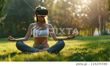 A woman practices meditation with a VR headset in a quiet garden, sitting in the lotus position on green lawn. Psychological health, relaxation, spiritual practices 114245599