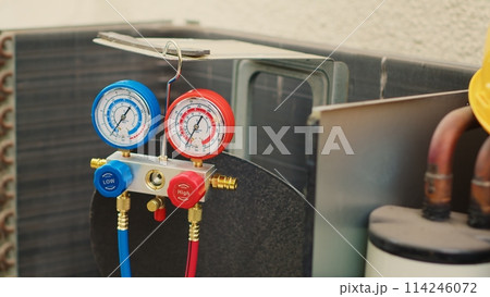 Dolly in close up shot of faulty pressure measurement device used for checking air conditioner refrigerant tank in need of fixing. Set of manifold indicators showing high or low freon levels Dolly in close up shot of faulty pressure measurement device used for checking air conditioner refrigerant tank in need of fixing. Set of manifold indicators showing high or low freon levels 114246072