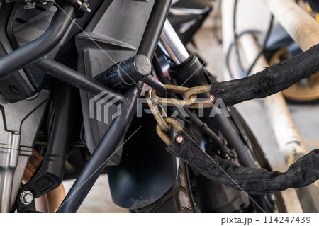 .Large chains and padlocks are used to protect motorcycles from thieves. 114247439
