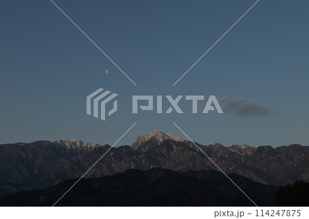朝日さす南アルプス甲斐駒ケ岳の稜線上の月 114247875