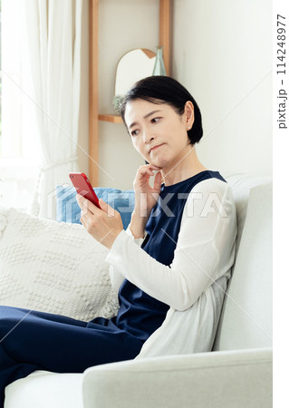 リビングでスマホを使う女性 114248977