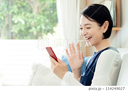 スマホを操作するミドル女性 114249027