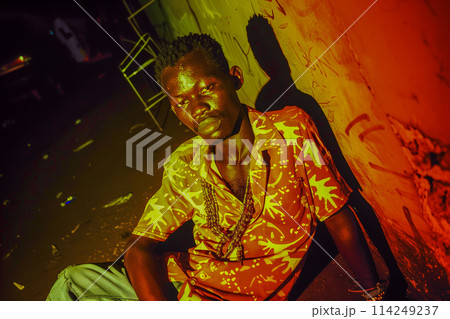 A man in a yellow shirt is sitting on the ground 114249237