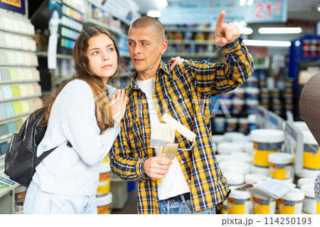 Woman and man points his hand at something in hardware store 114250193