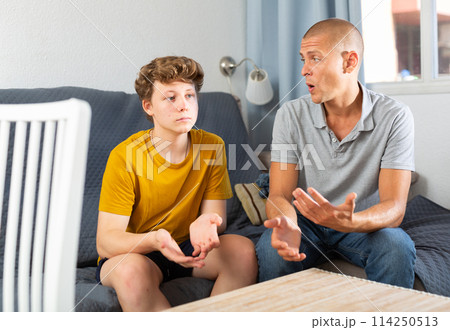 Father and his son sitting on sofa 114250513