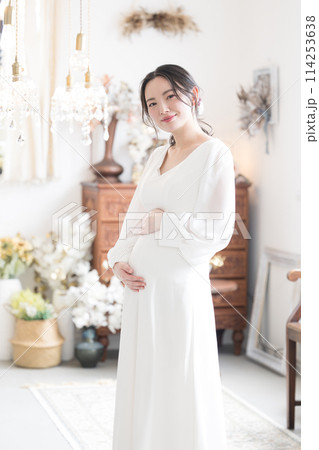 結婚式のマタニティフォトのイメージ　カメラ目線　前撮りや幸せいっぱいの妊婦さんのイメージ 縦 114253638
