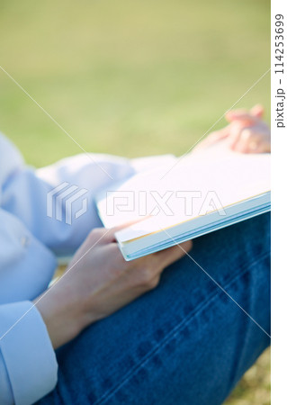 芝生の上で本を読む女性 芝生の上で本を読む女性 114253699