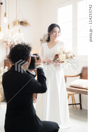 ウエディングフォトや記念写真を撮影するカメラマン 縦 ウエディングフォトや記念写真を撮影するカメラマン 縦 114253742