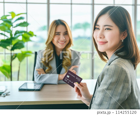 ホテルのフロントでクレジットカードで支払いする女性_1 114255120